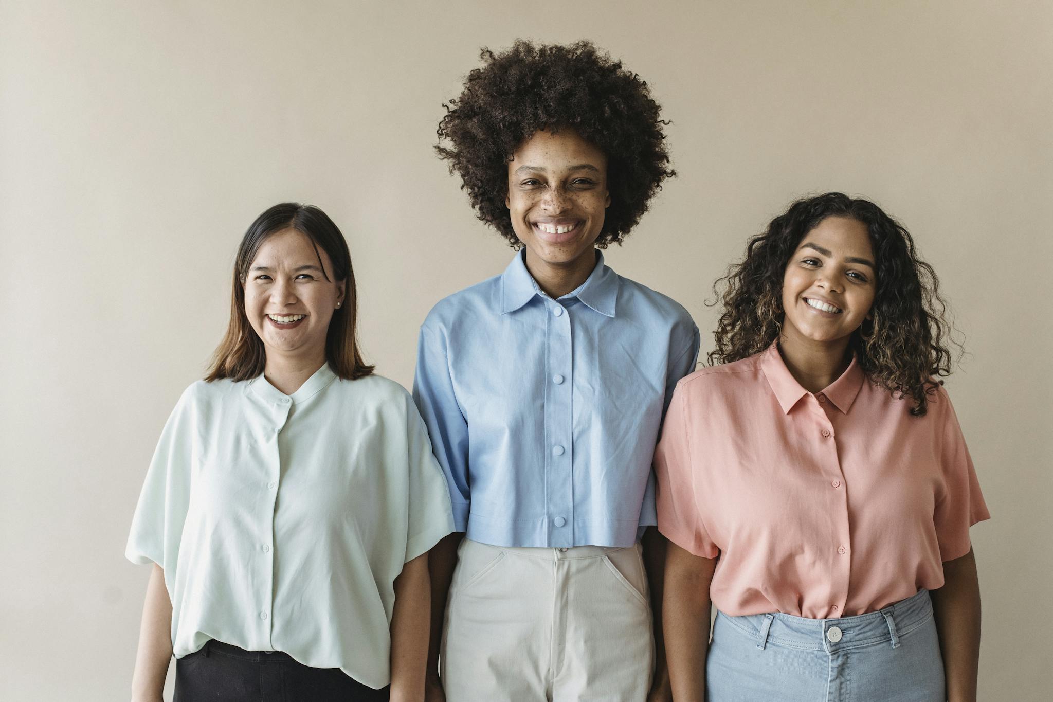 A joyful portrait of three diverse businesswomen confidently smiling. Ideal for business and diversity themes.